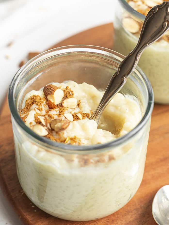 oat milk rice pudding in a glass jar with a spoon