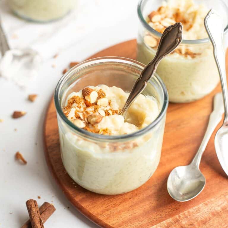 oat milk rice pudding in a glass jar with a spoon