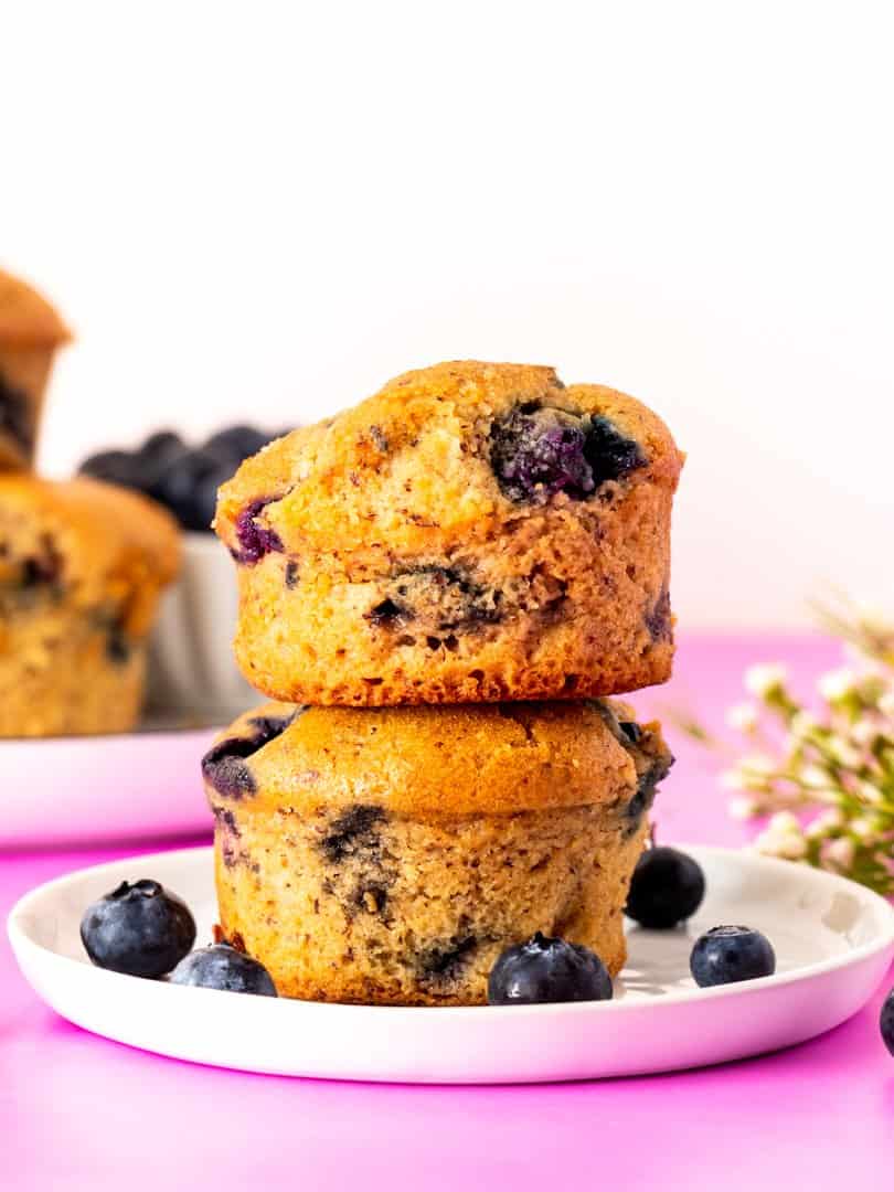 stacked gluten free blueberry muffins on a white plate