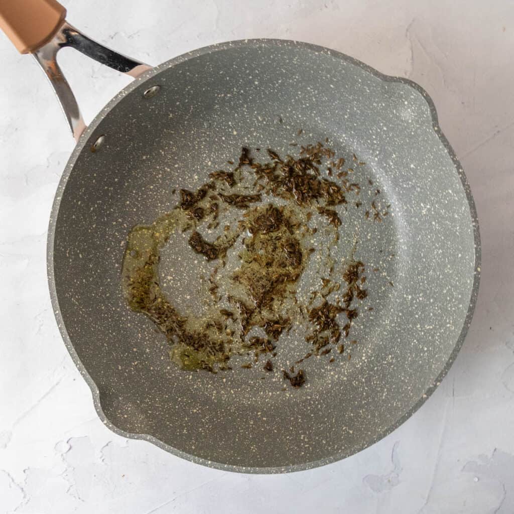 sautéed cumin seeds in a pan