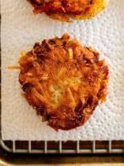 gluten free latkes on a wire rack with a paper towel