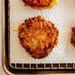 gluten free latkes on a wire rack with a paper towel