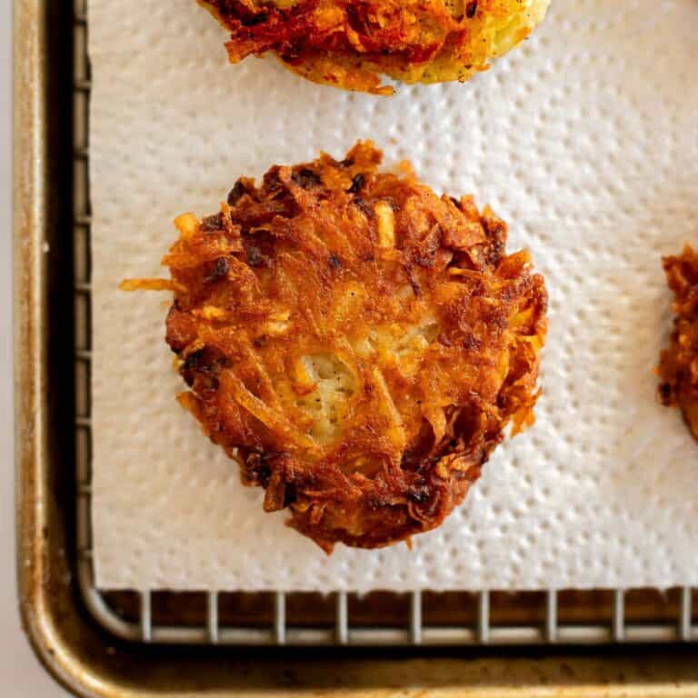 gluten free latkes on a wire rack with a paper towel