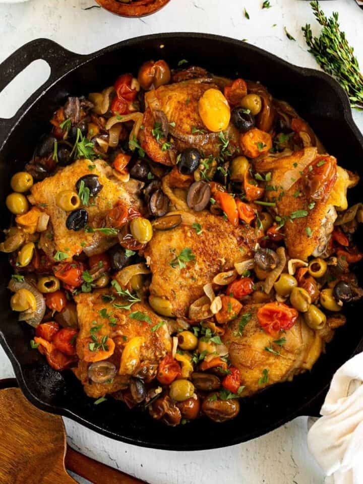 Chicken Thighs with Tomatoes and Olives in a cast iron skillet