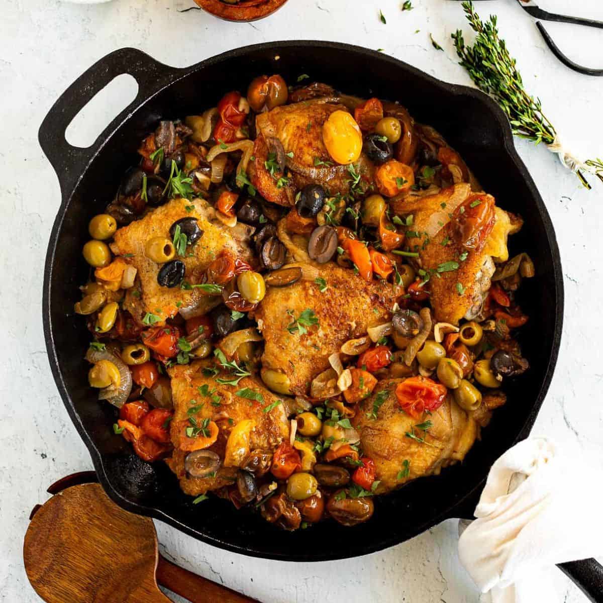 Chicken Thighs with Tomatoes and Olives in a cast iron skillet