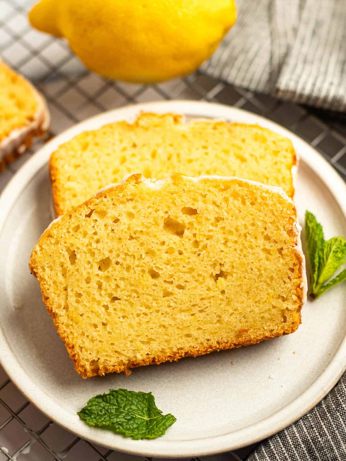 two slices of lemon drizzle cake that is gluten free with fresh mint