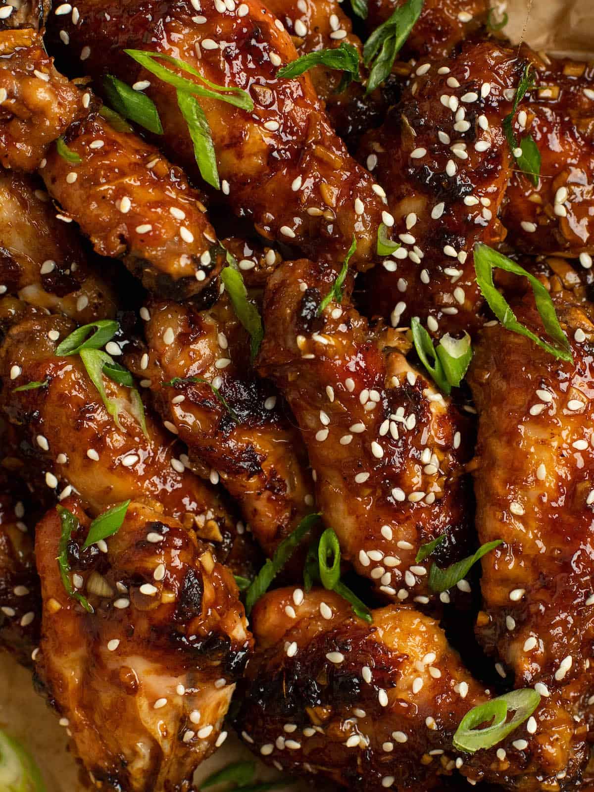 up close sticky chicken wings with sesame seeds and scallions