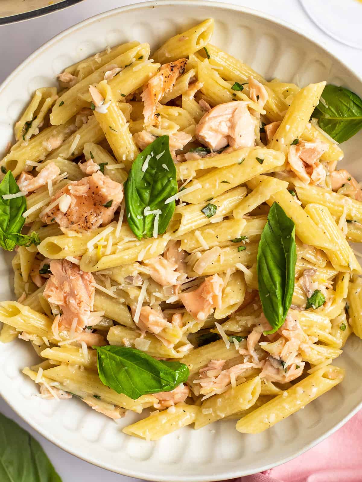 penne al salmone in a white bowl with basil