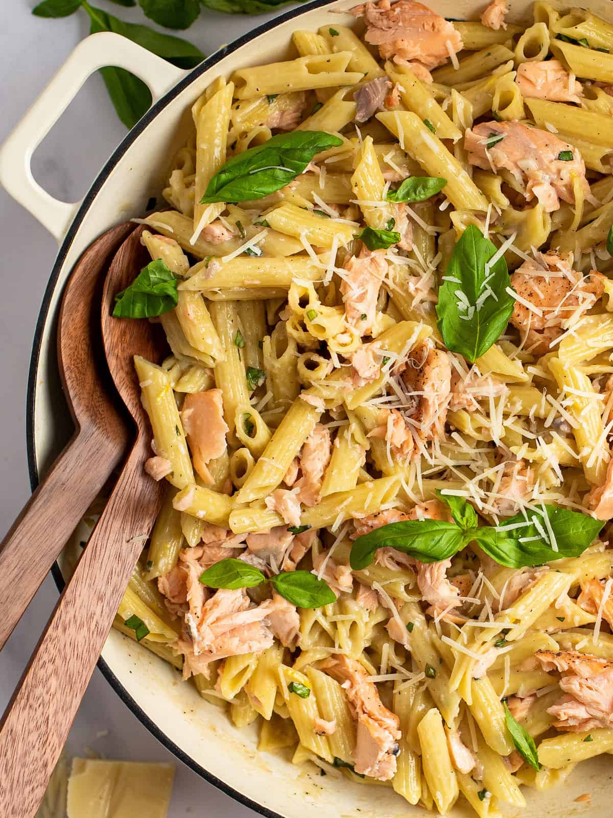 penne al salmone in a white dutch oven with serving spoons