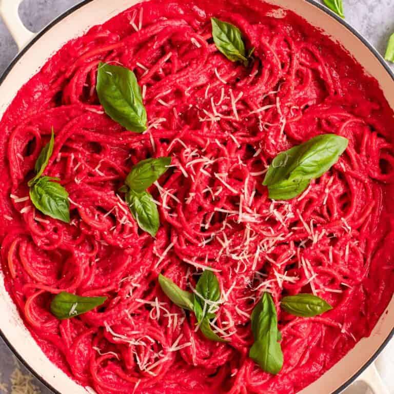 pink beet sauce barbie pasta in a white pan with basil and parmesan