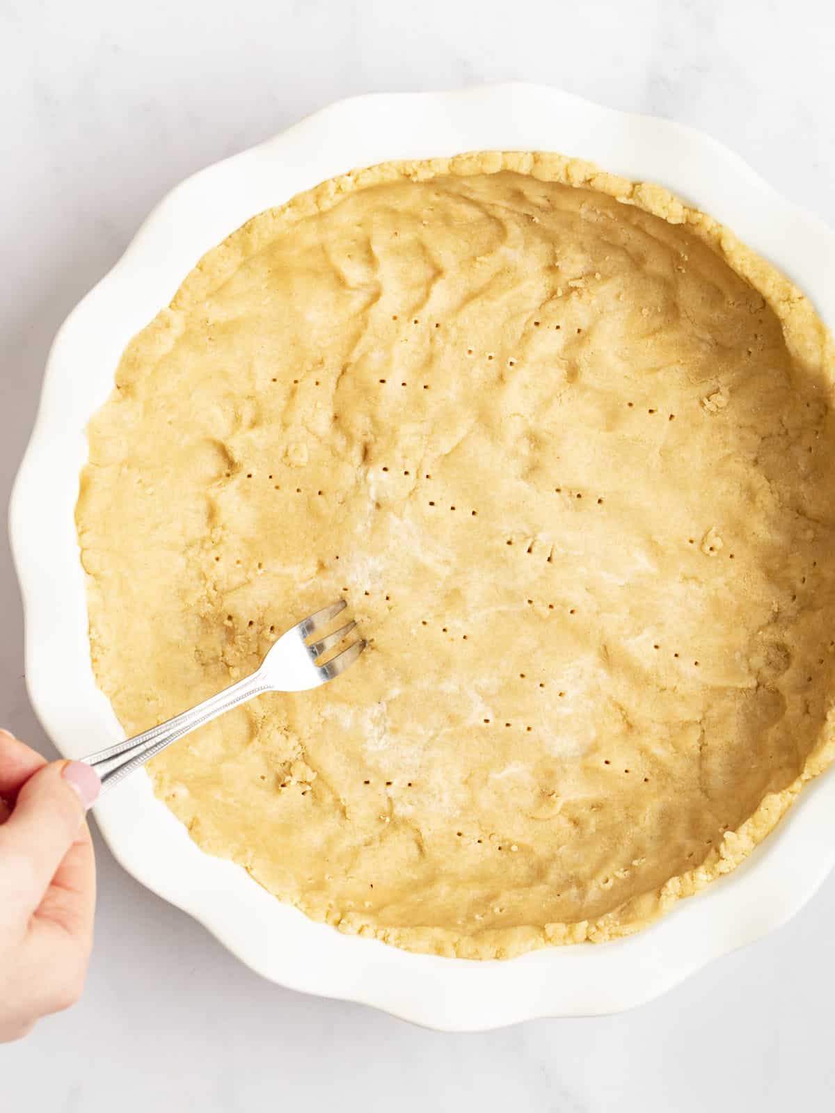 poking gluten free pie crust with a fork