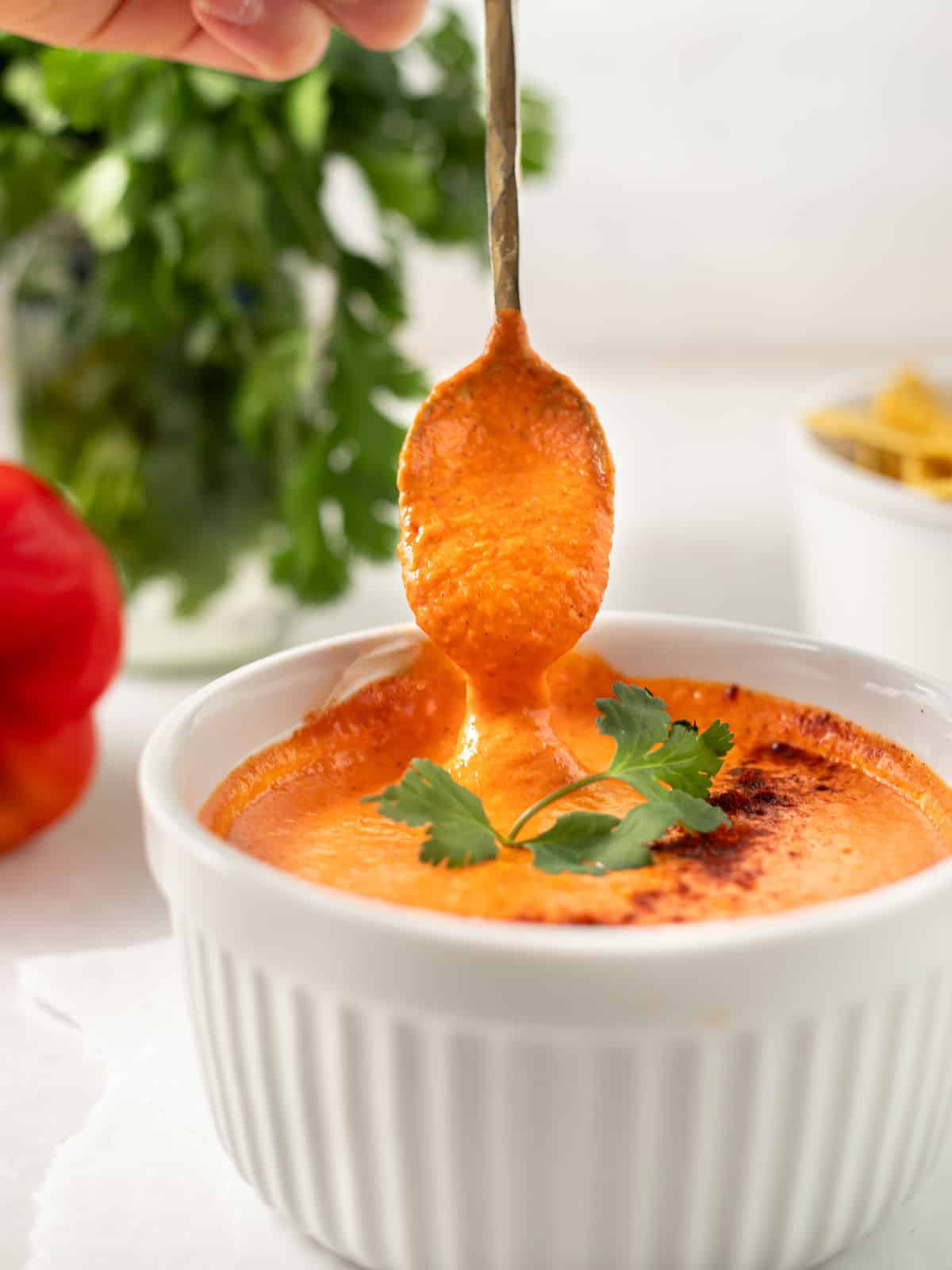 smoky red pepper crema in white bowl with spoon