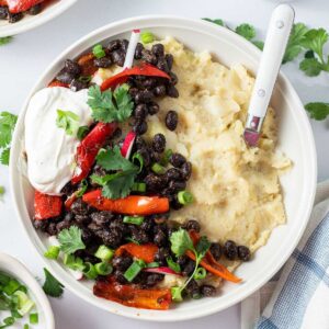 loaded mashed potato bowl with toppings and a spoon