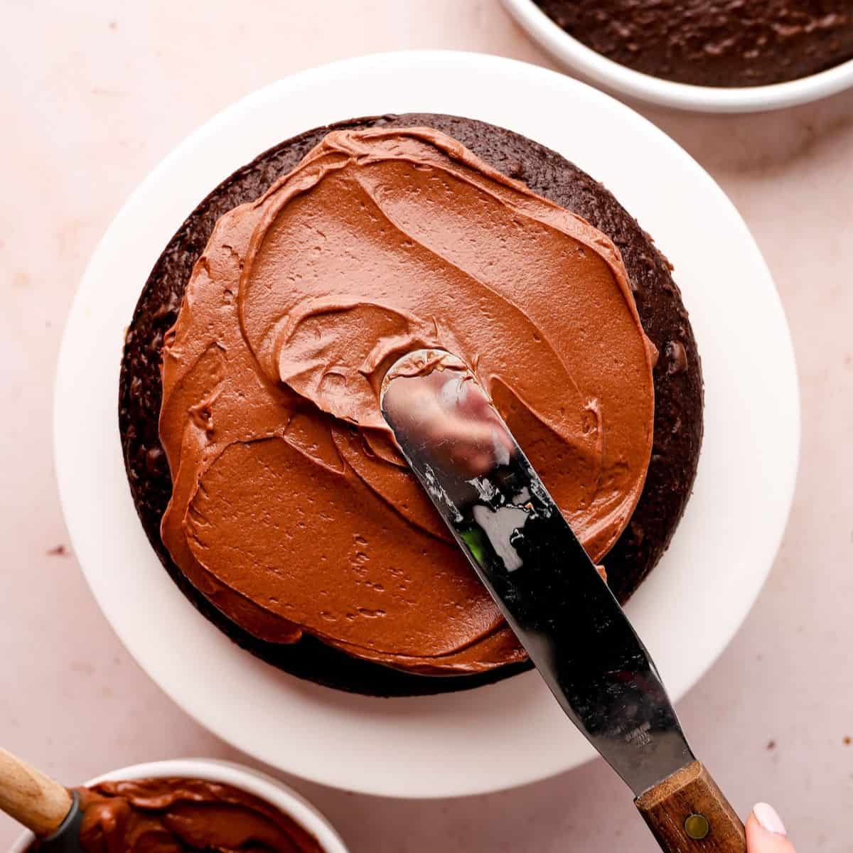 chocolate filling spread onto a chocolate cake layer with icing spatula