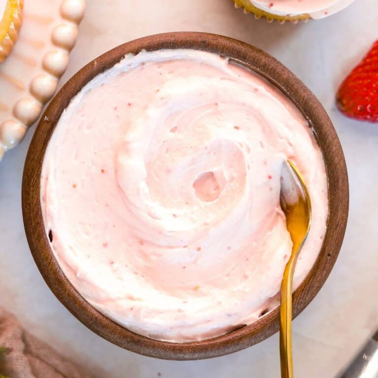 strawberry cheesecake filling for cake in a wooden bowl with gold spoon
