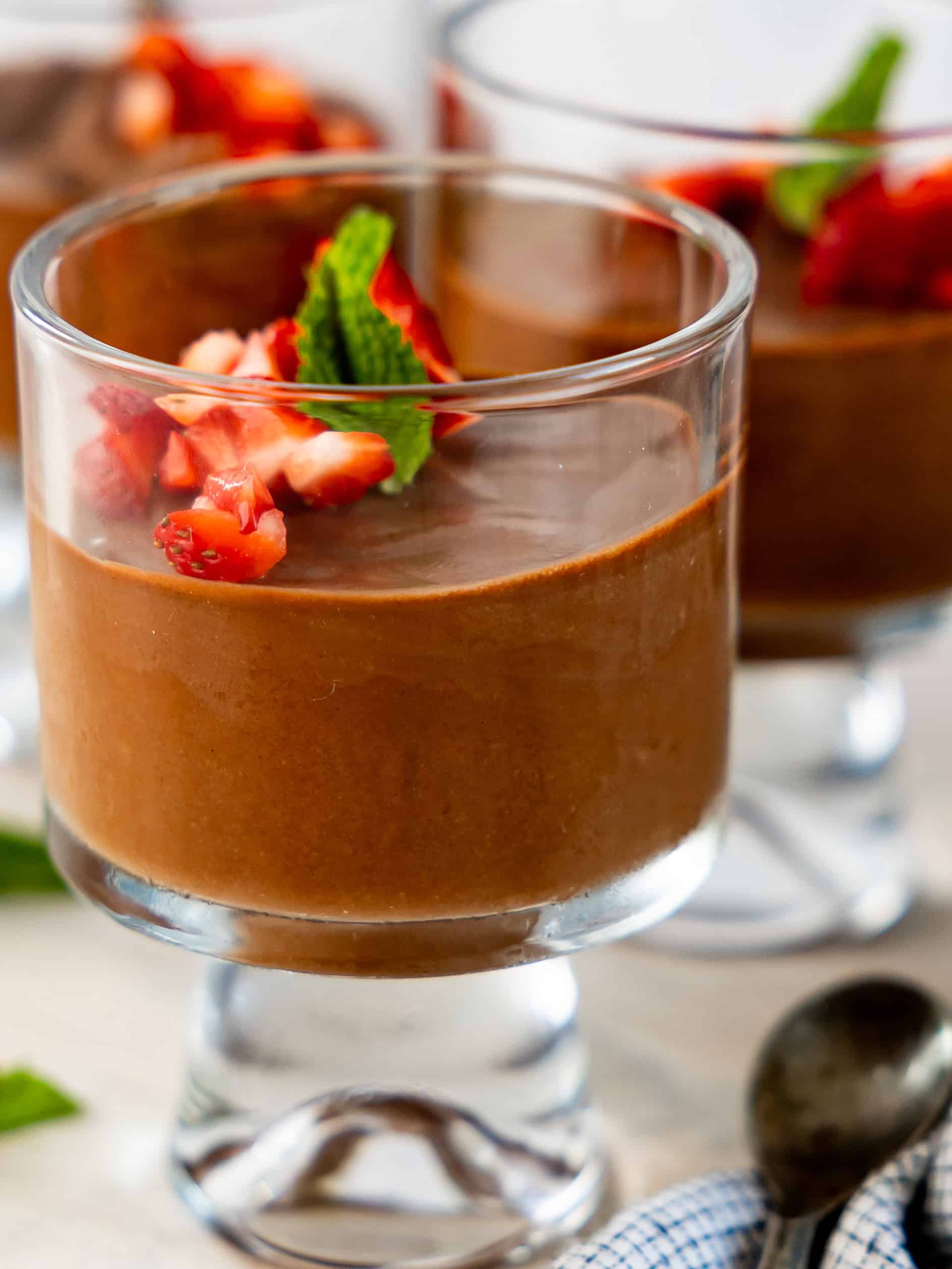 Small glass cup with chocolate mousse and strawberry topping