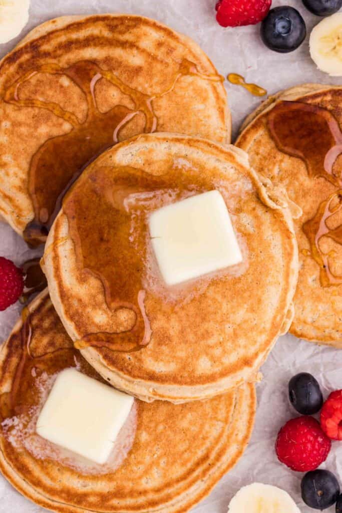 fluffy gluten-free oat flour pancakes stacked with butter and fresh berries
