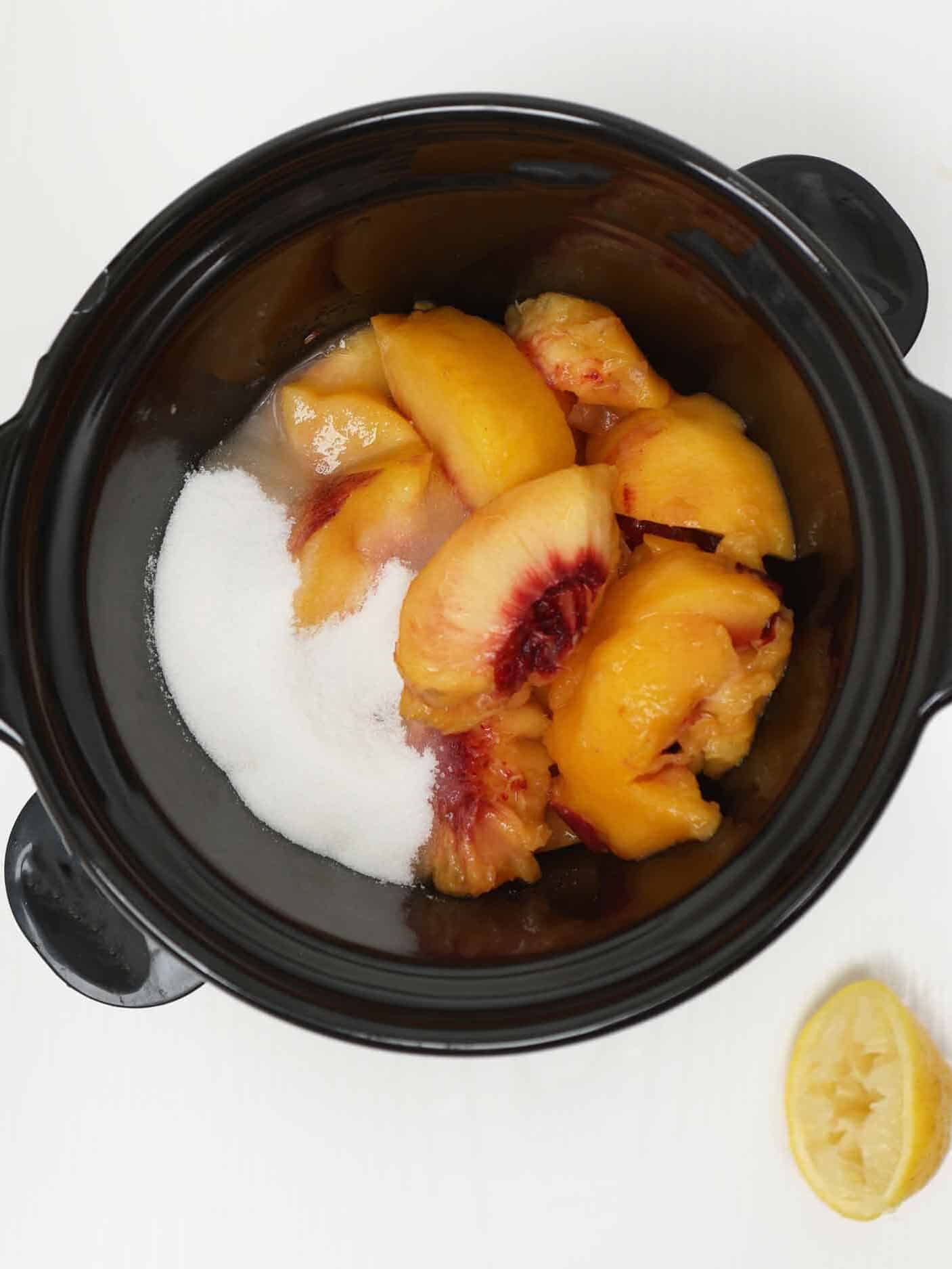 Peaches, sugar, lemon juice, and spices stirred together in the crockpot