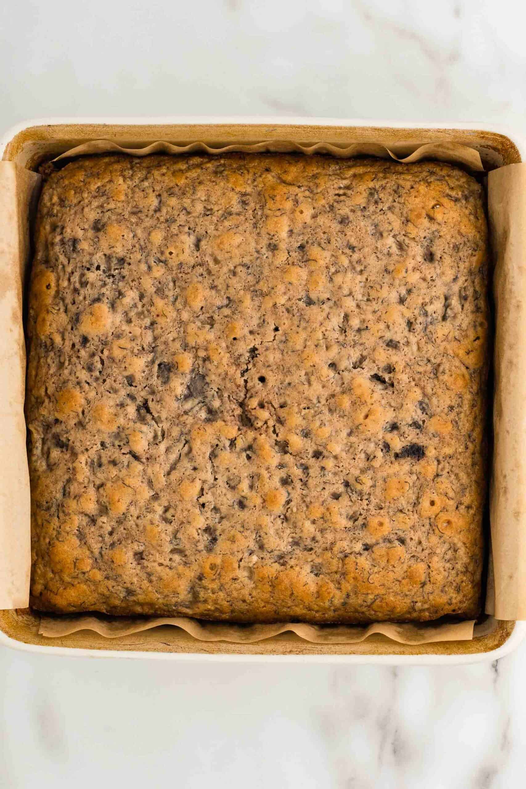 Baked gluten-free banana cake in a parchment-lined square pan