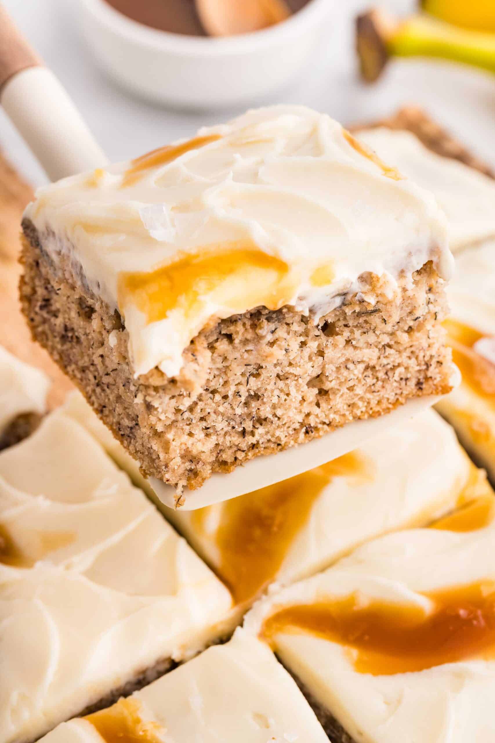 A square of gluten-free banana cake lifted from the pan showing the soft crumb