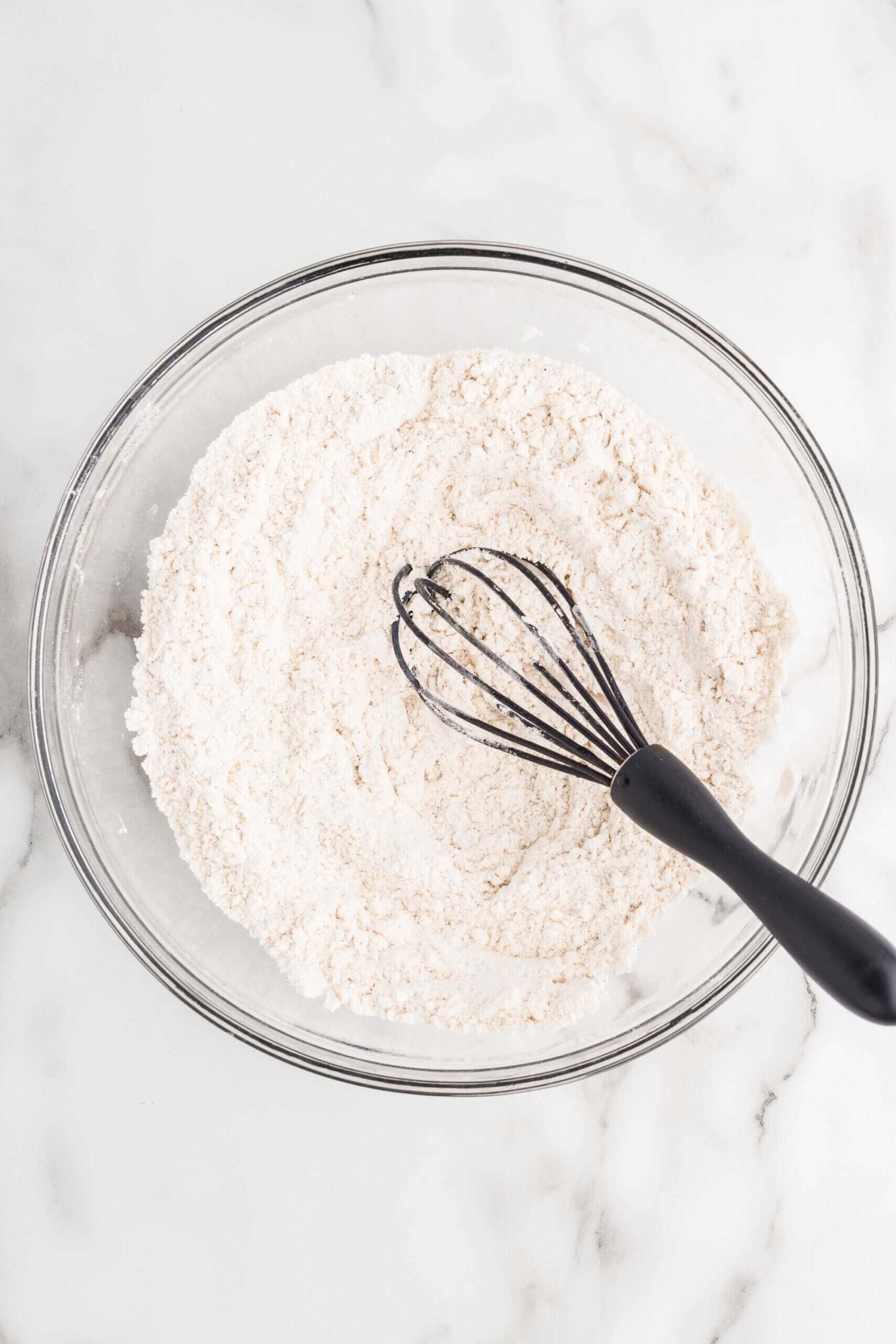 Gluten-free flour, baking soda, baking powder, cinnamon, and salt whisked together in a glass bowl