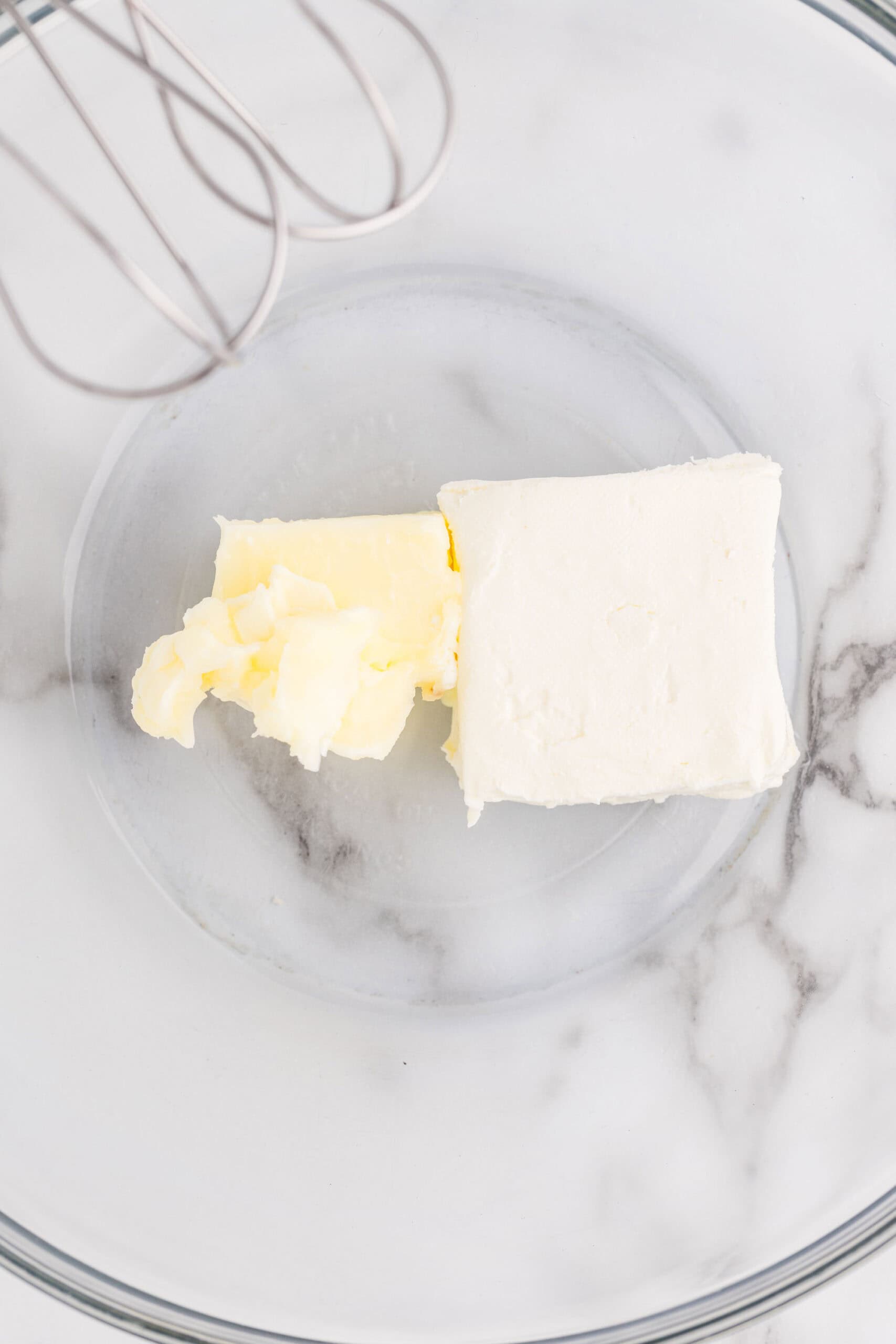 Softened butter and cream cheese in a glass mixing bowl